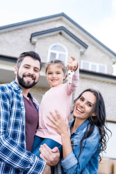A happy family holding the keys to their new home